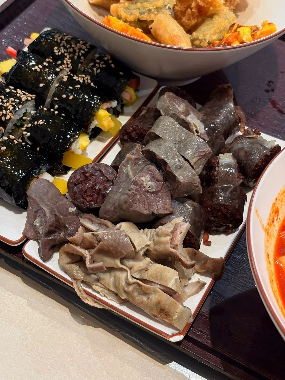 Fried snack being dipped into tteokbokki broth
