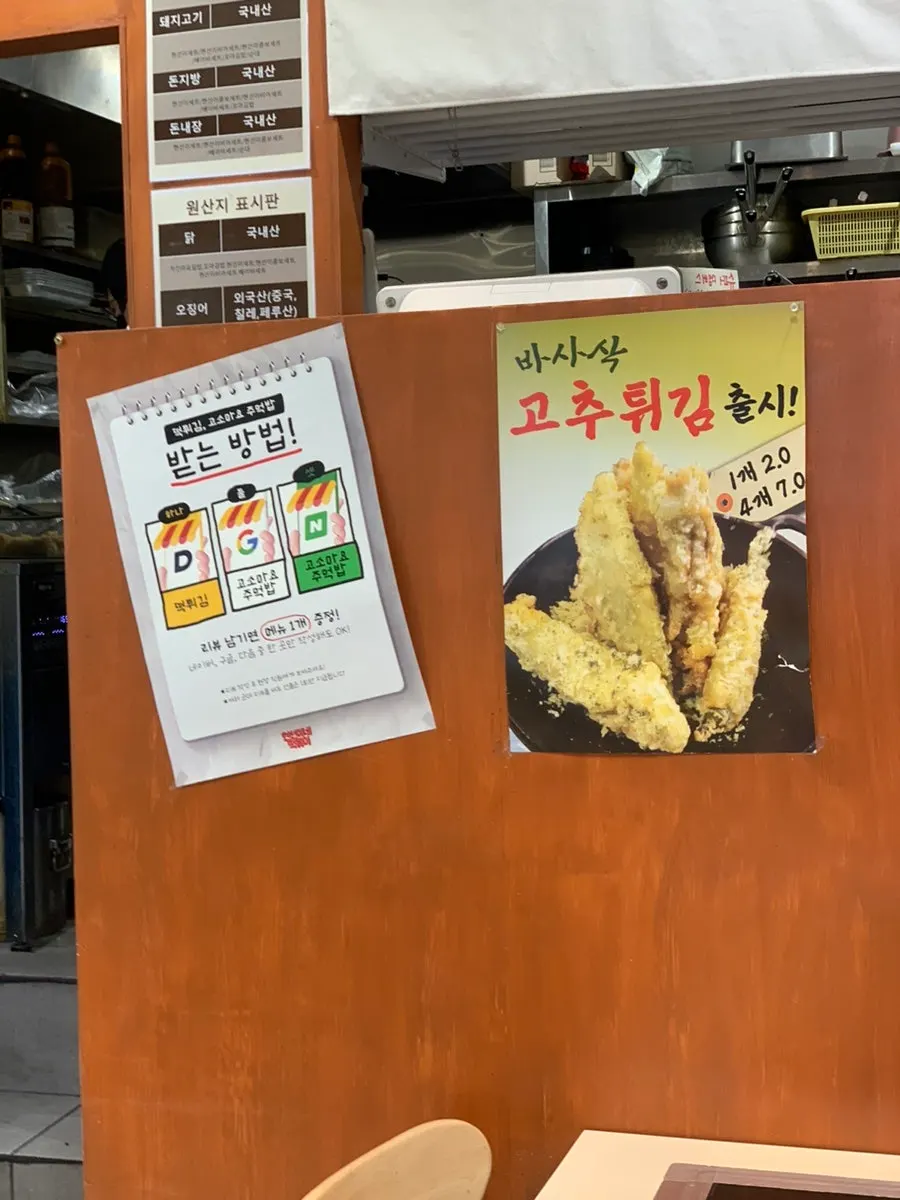 Review event sign offering tteok fritters or sesame mayo rice ball
