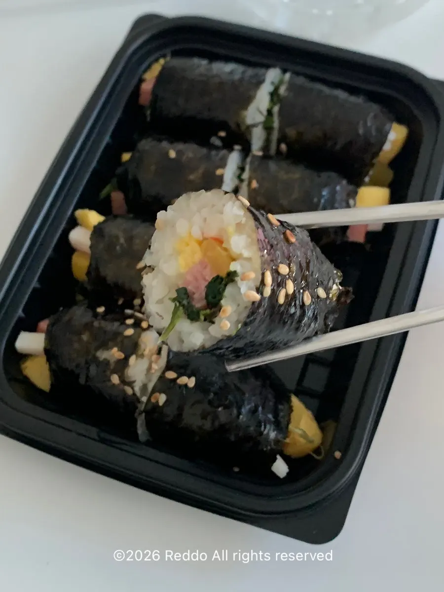 Tteokbokki, fried snacks, sundae, and gimbap laid out at home