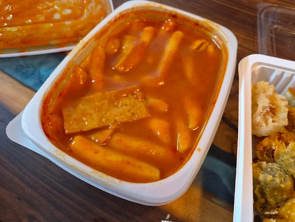 Tteokbokki, gimbap, sundae, and fried snacks laid out at home