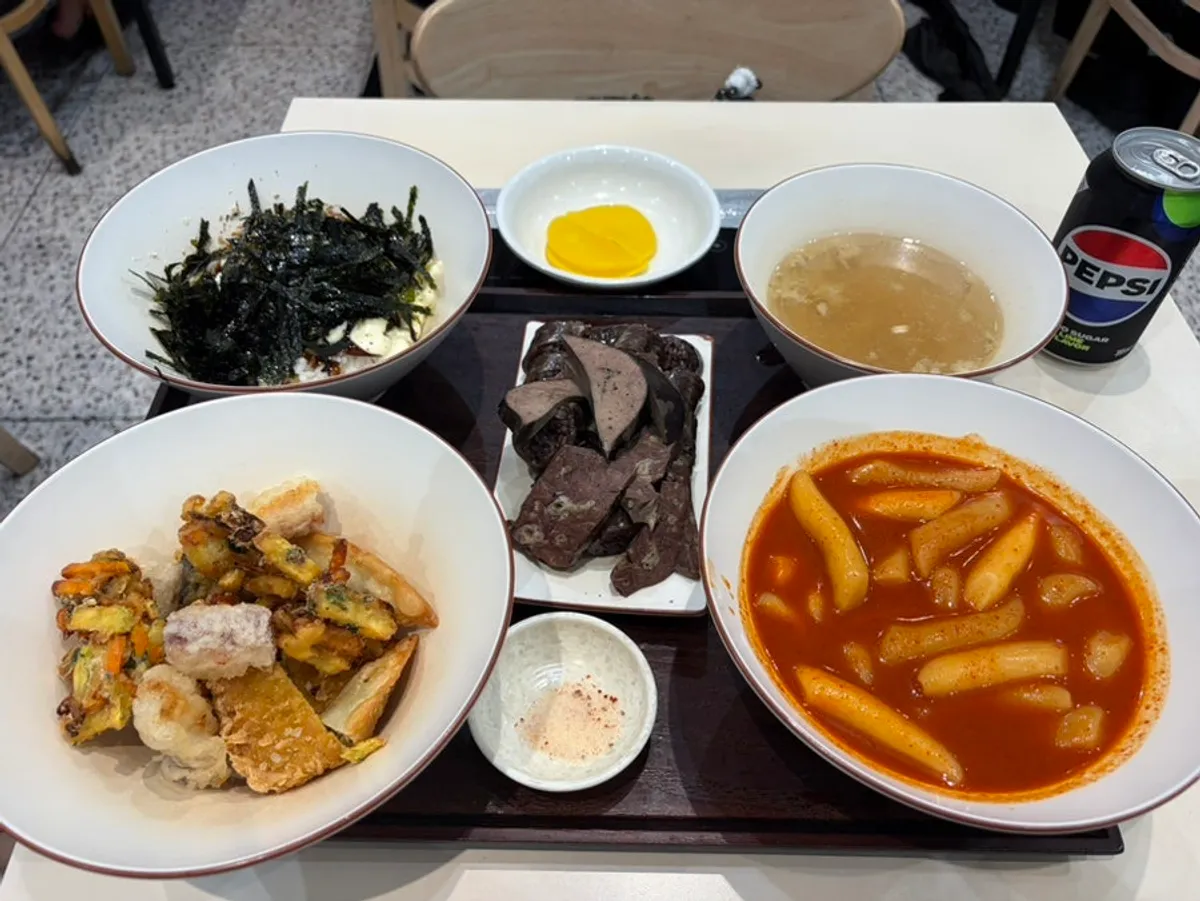 Full spread of the Hyeonseonine Set with tteokbokki, fried snacks, sundae, and rice ball