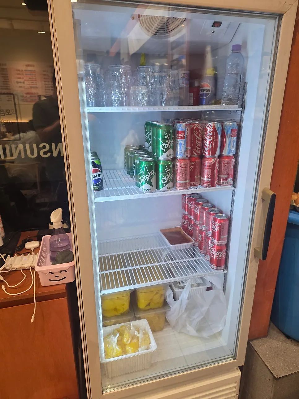 Commercial fridge stocked with cola and cider