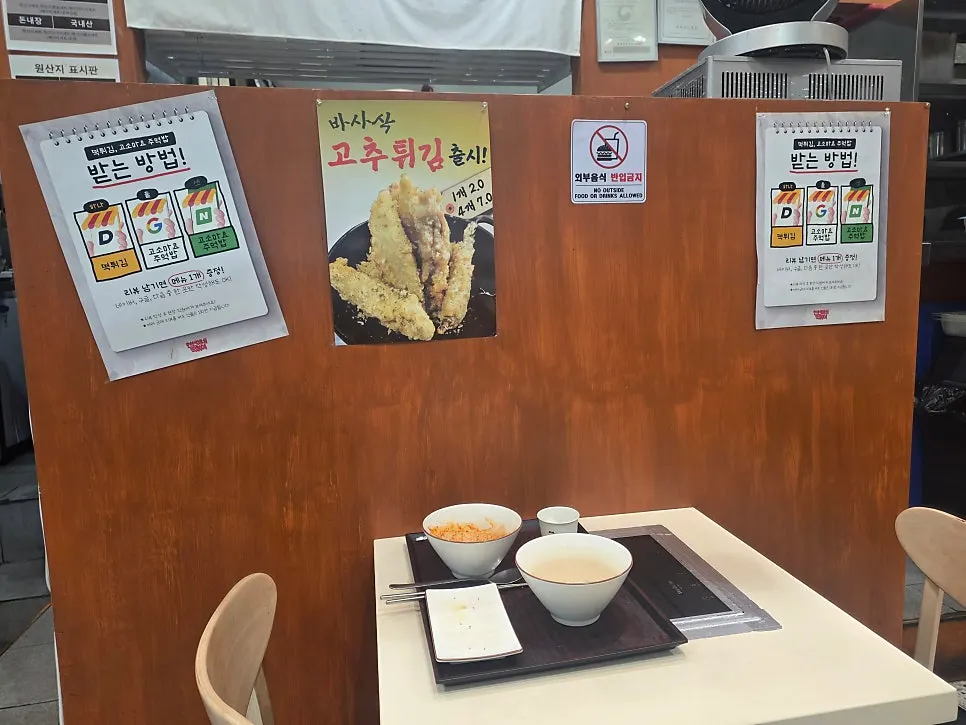 Wooden pickup-station wall with the Hyeonseonine logo and mascot board