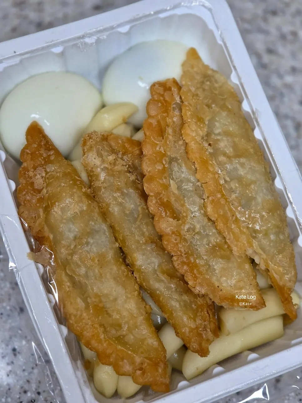 Pot with vegetables topped with rice cakes, eggs, dumplings, and fish cake