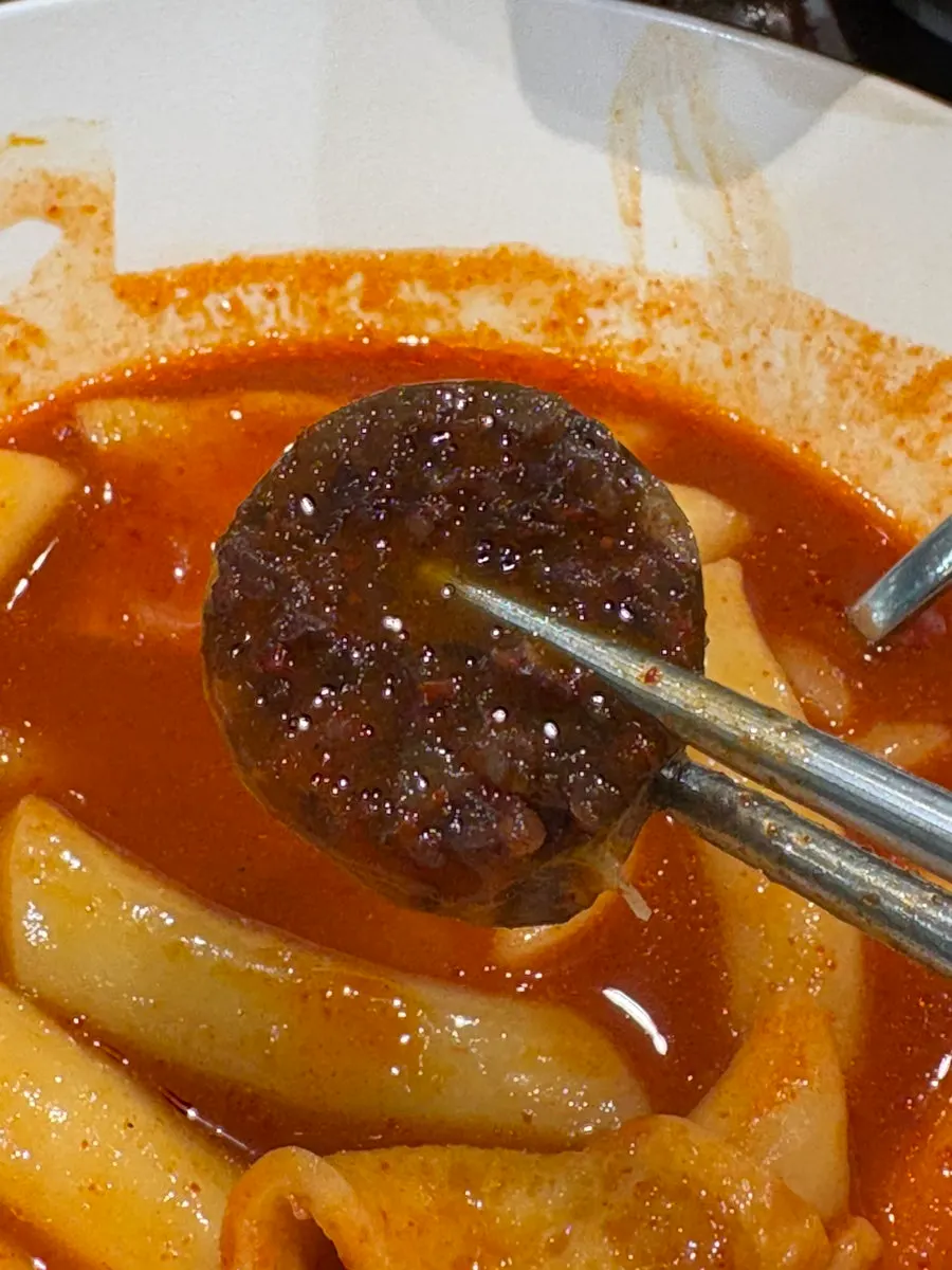떡볶이 국물에 찍어 먹는 순대 한 점