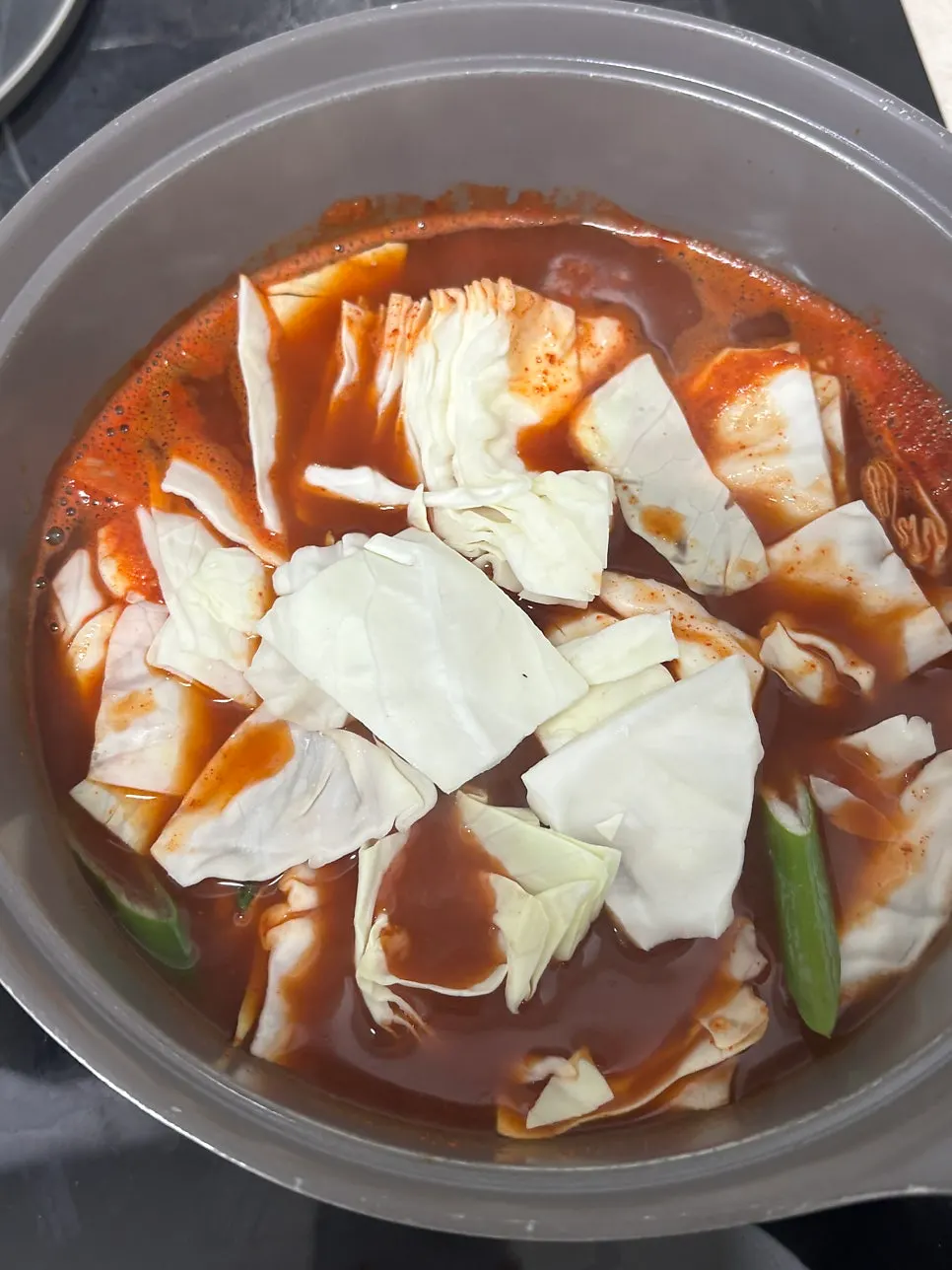 Pouring liquid sauce and water into a pot to boil