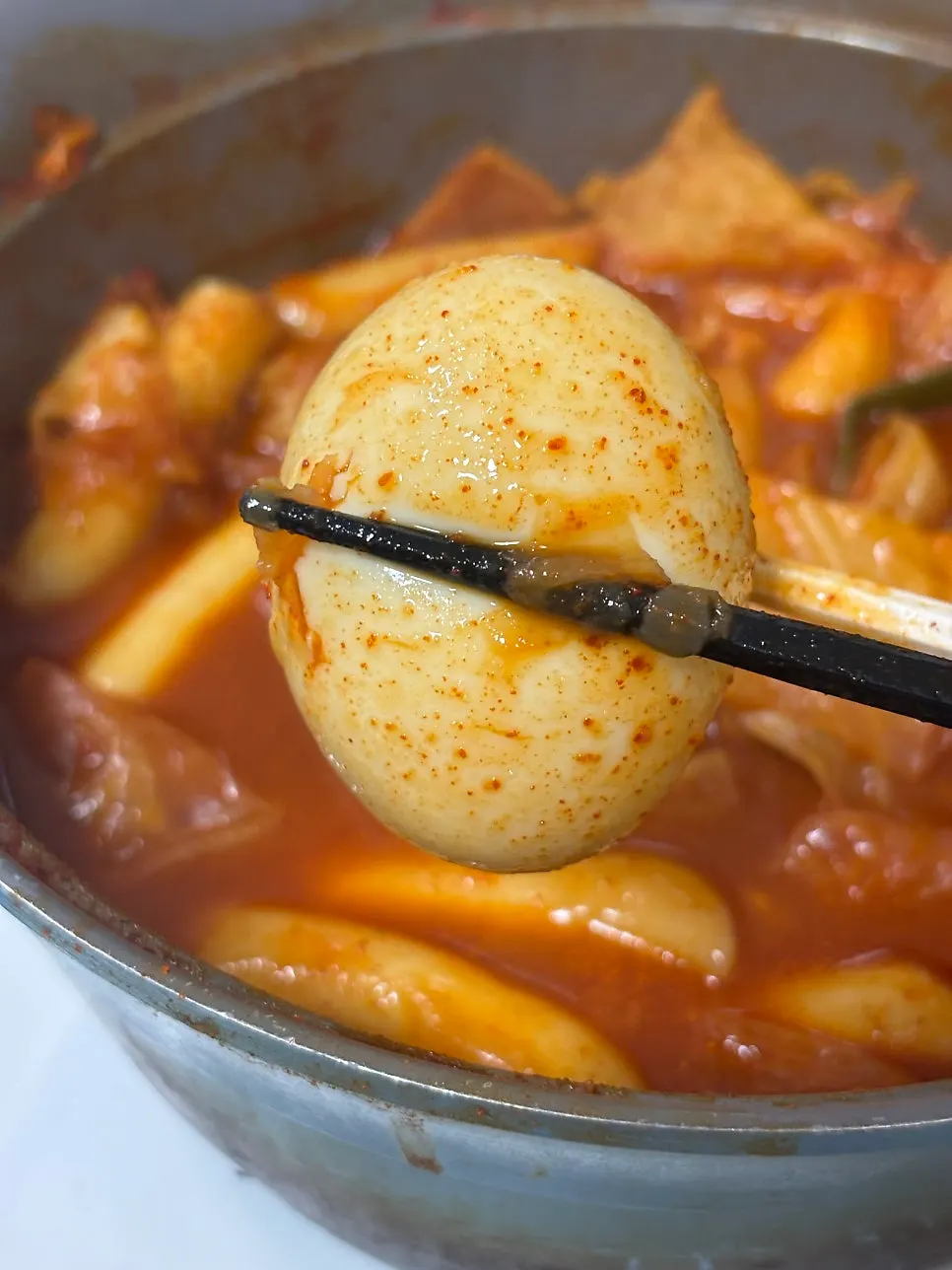 Ramen noodles cooked in the tteokbokki broth being lifted out