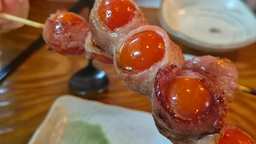Close-up of bacon wrapped cherry tomato skewer