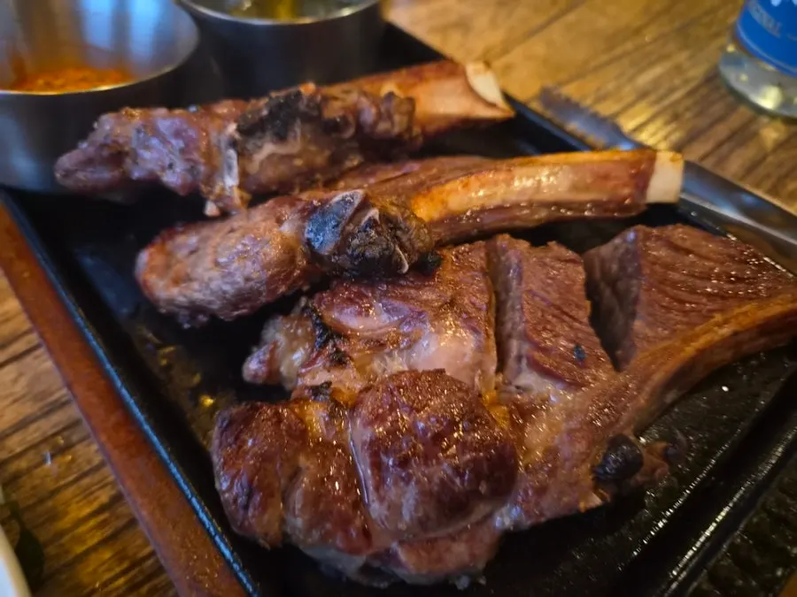 Lamb shoulder rack sizzling on the hot plate