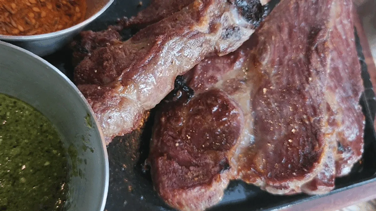Lamb shoulder rack sizzling on a hot plate