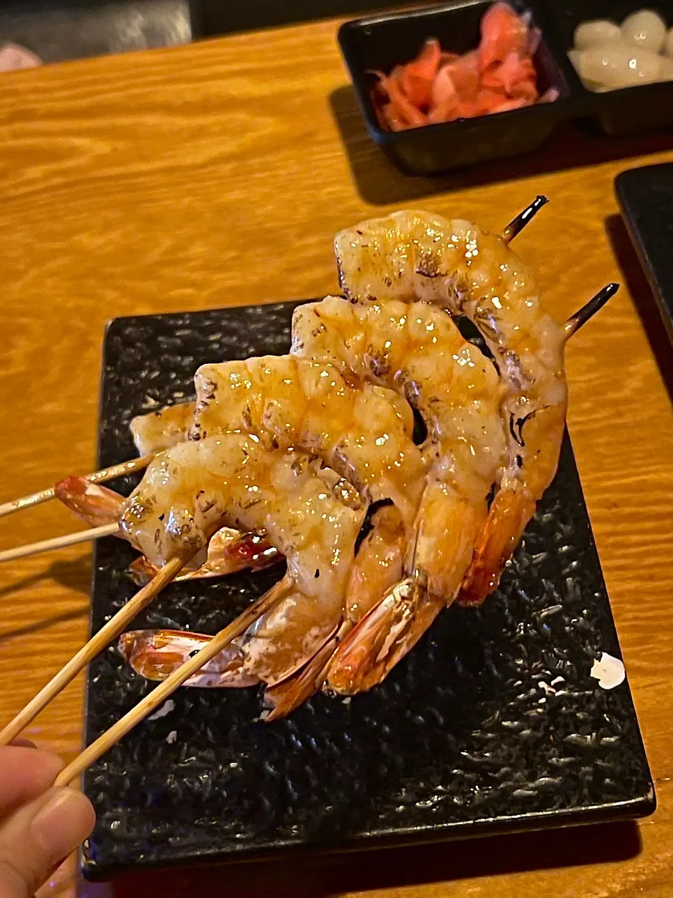 Close-up of a grilled shrimp being picked up