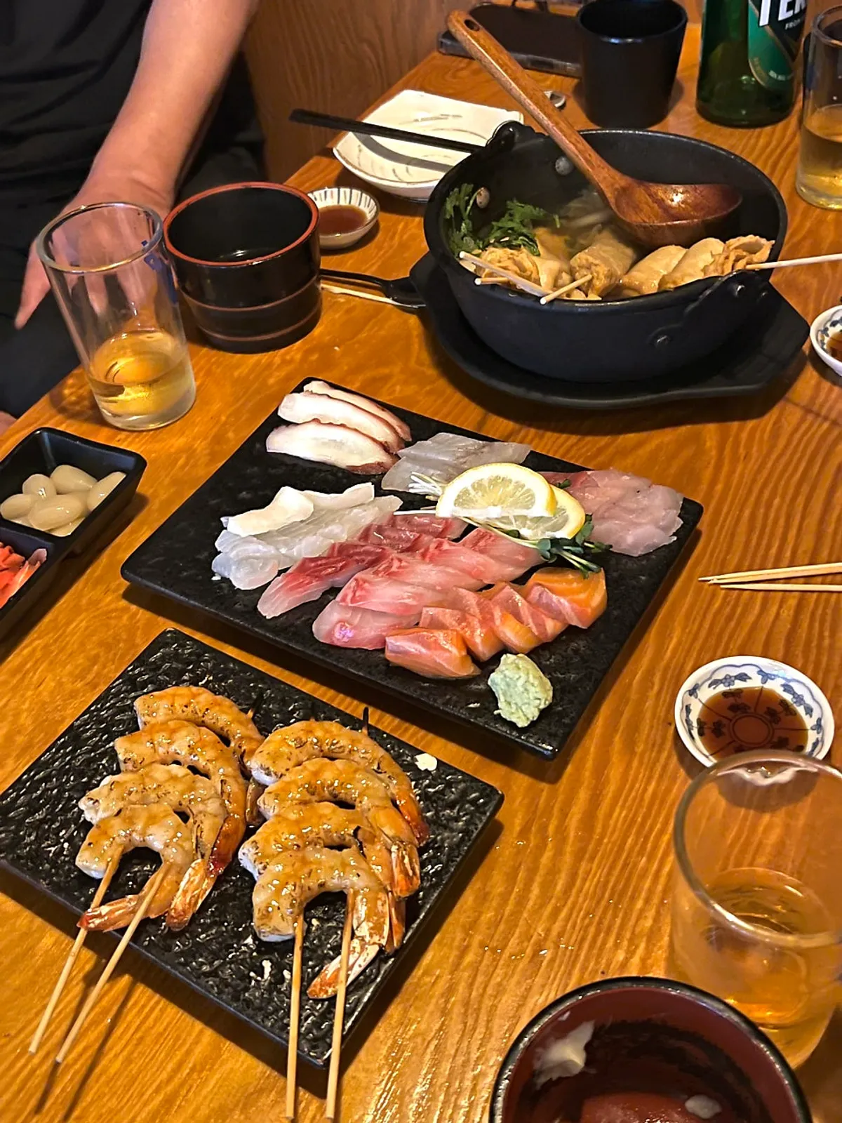 Izakaya table filled with sashimi and grilled dishes