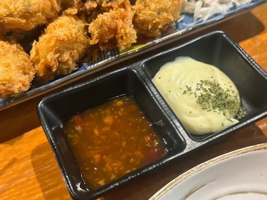 Sauce and cabbage served with the oyster fritter