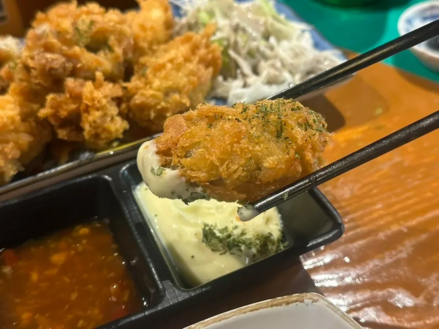 Oyster fritter dipped in sauce