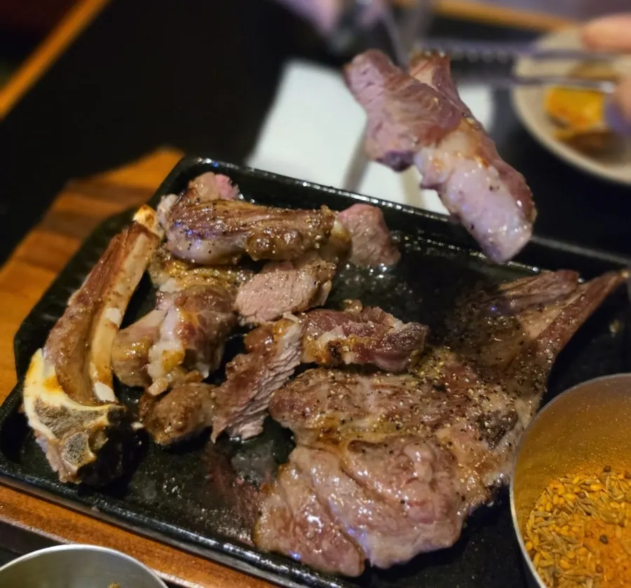 Table spread with lamb and spicy seafood tteokbokki together