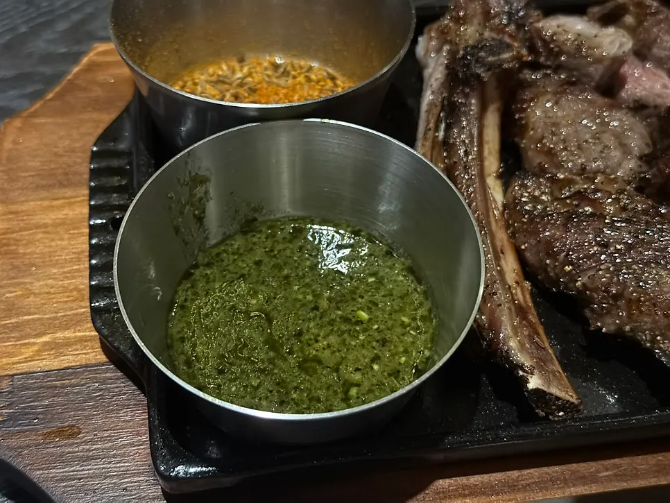 Thinned basil pesto sauce served alongside the lamb ribs