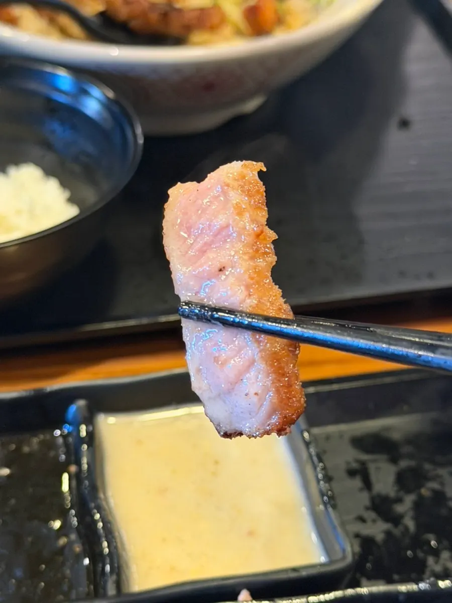 A piece of gyukatsu dipped in yuzu sauce