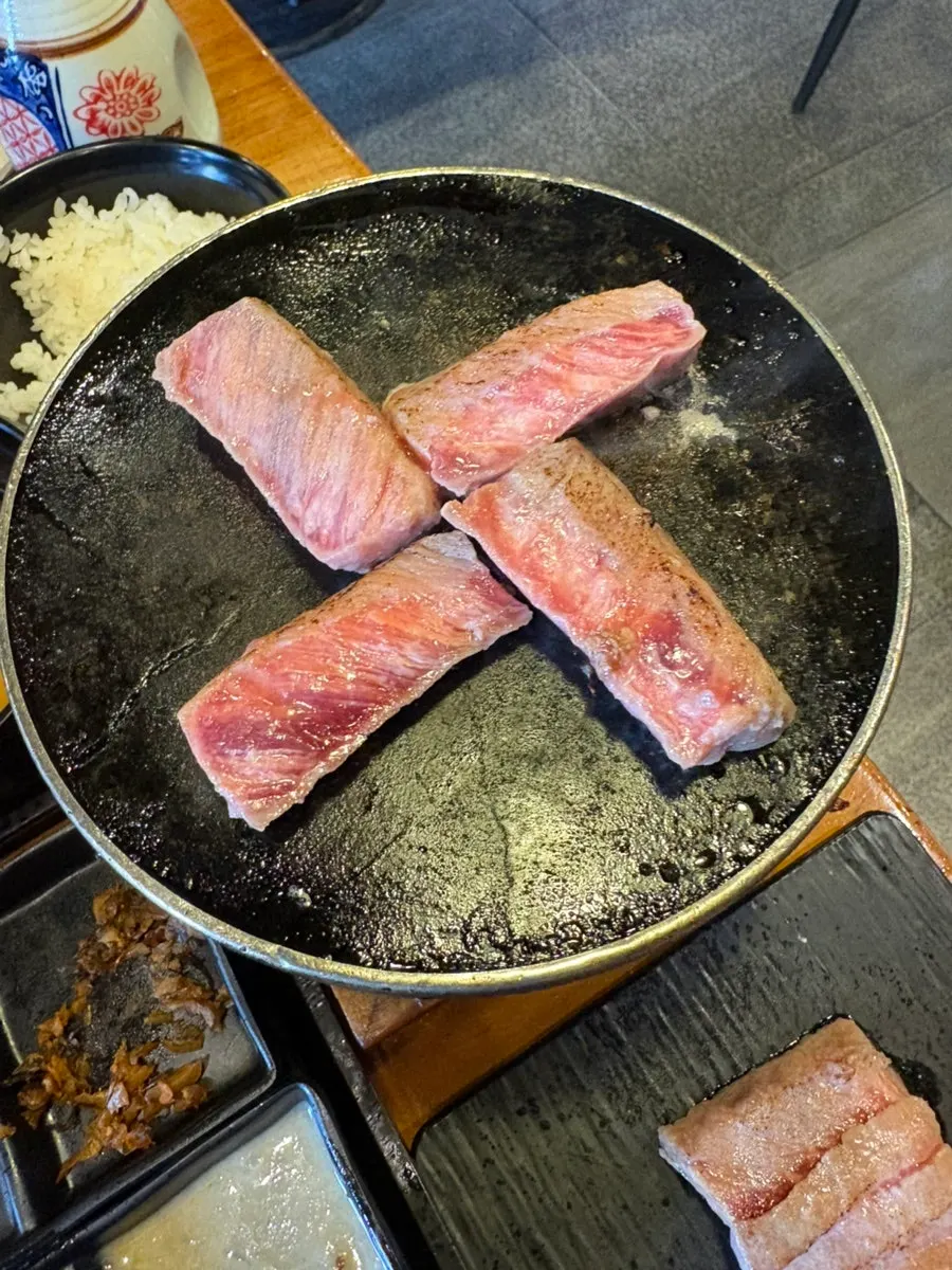 Striploin steki grilling on the brazier