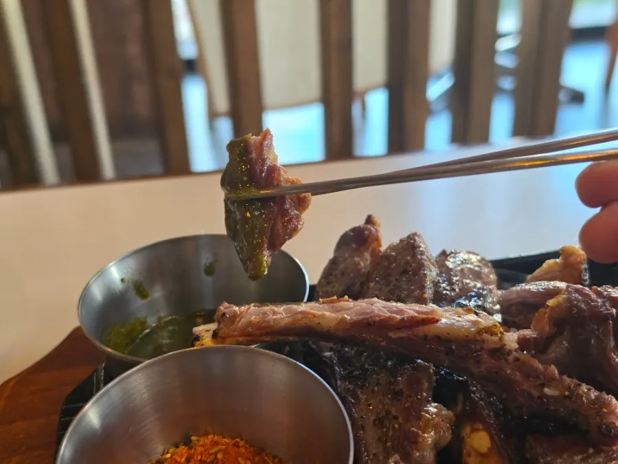 A piece of lamb dipped in sauce