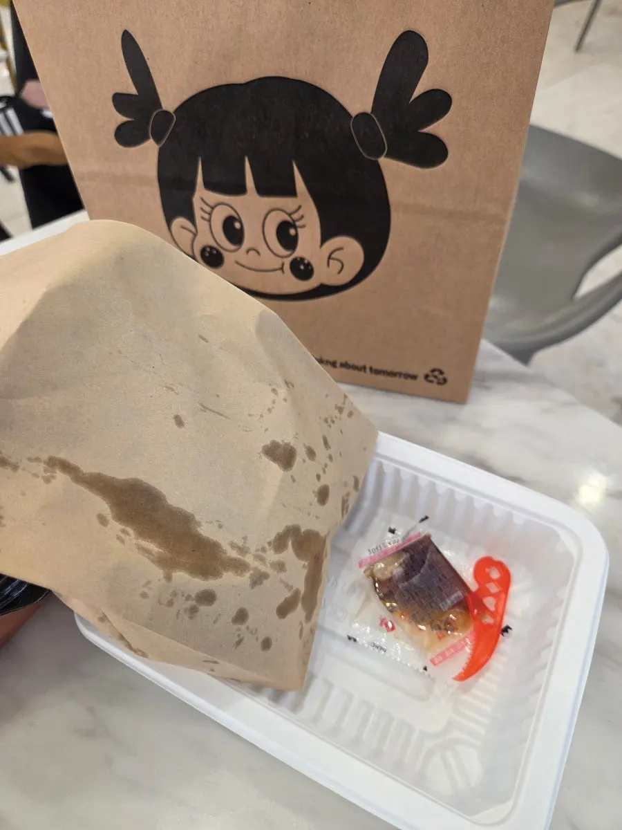 Tteokbokki with plastic wrap removed on a picnic mat