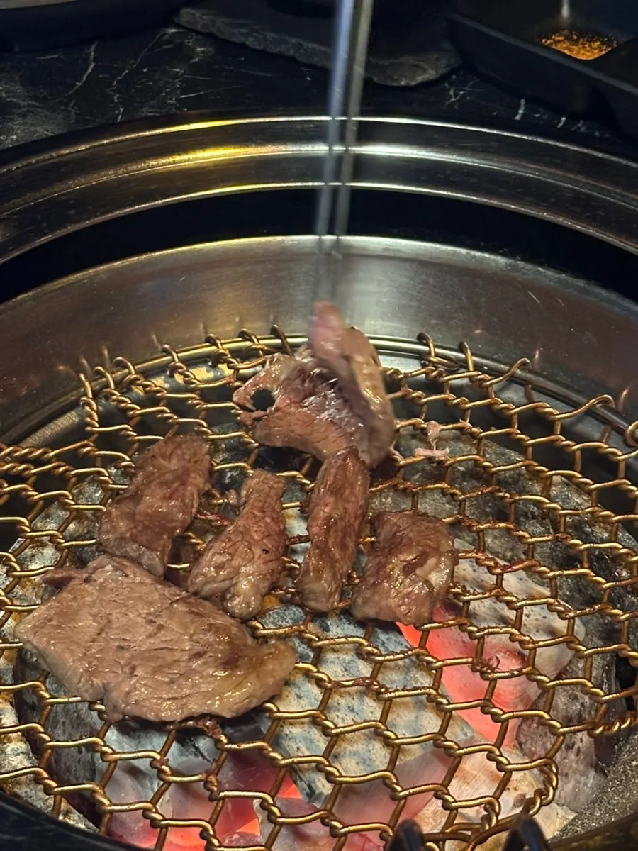 Grilling meat on a heated charcoal grill