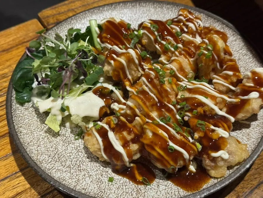 Lamb shoulder rack served on a hot plate with cumin and basil sauce