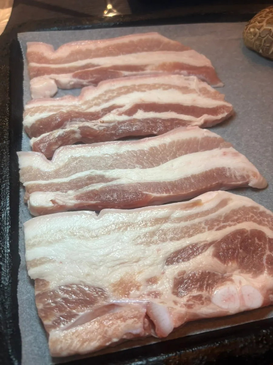 Pork belly skin browning nicely on the grill