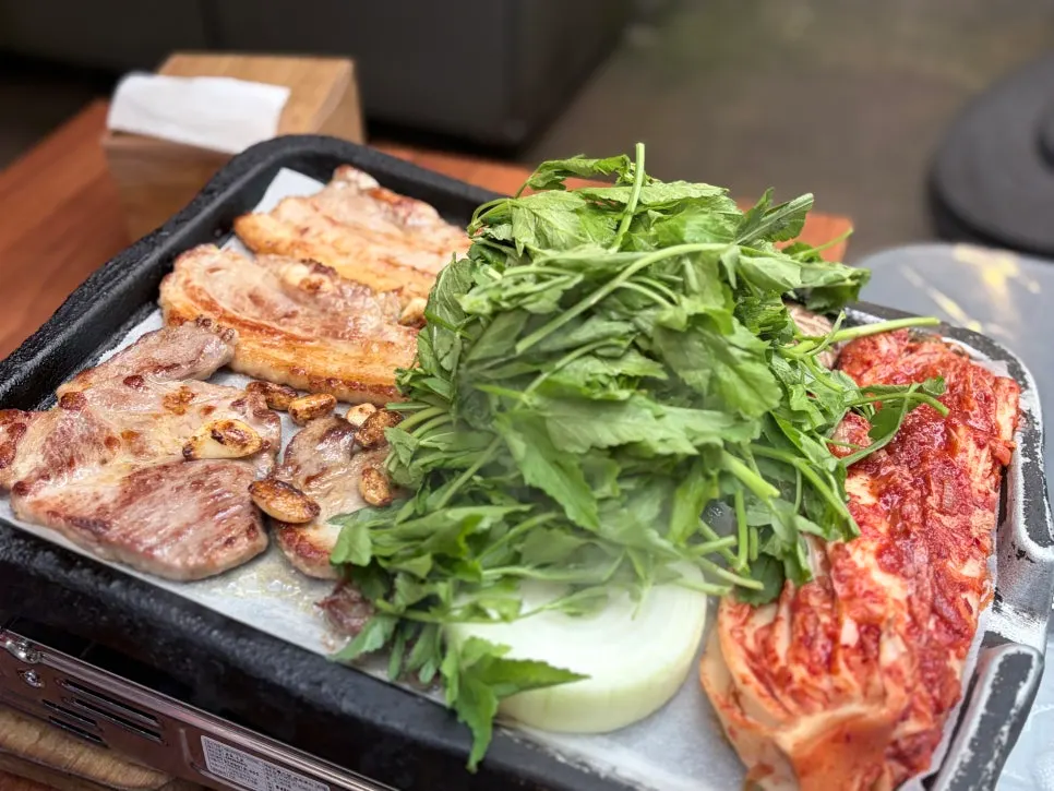 Kimchi and minari cooking alongside the pork belly