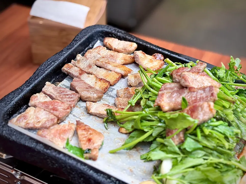 A full spread of meat, kimchi, and bean sprout scallion salad