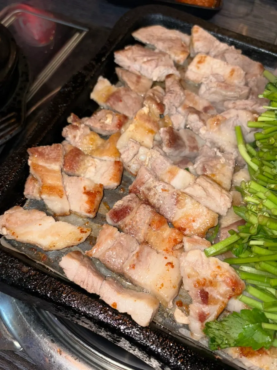 미나리 위에 올려둔 익은 삼겹살