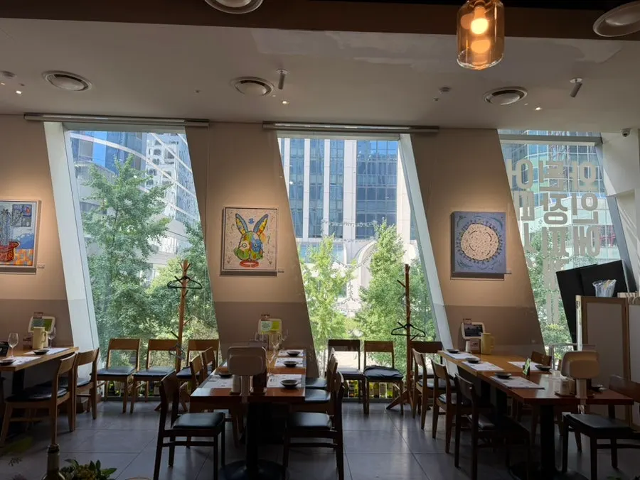 View of buildings and green trees through the window