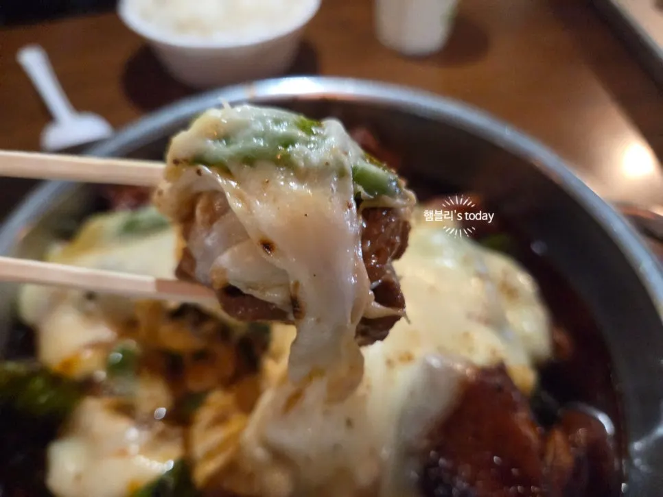 A bite of chicken topped with shishito pepper and cheese