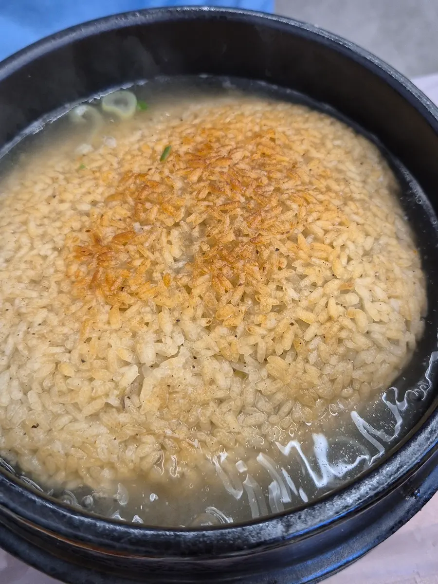 Herbal samgyetang topped with a whole piece of scorched rice