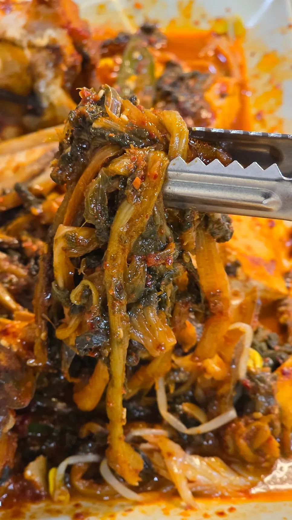 A chopstick-full of radish greens lifted up