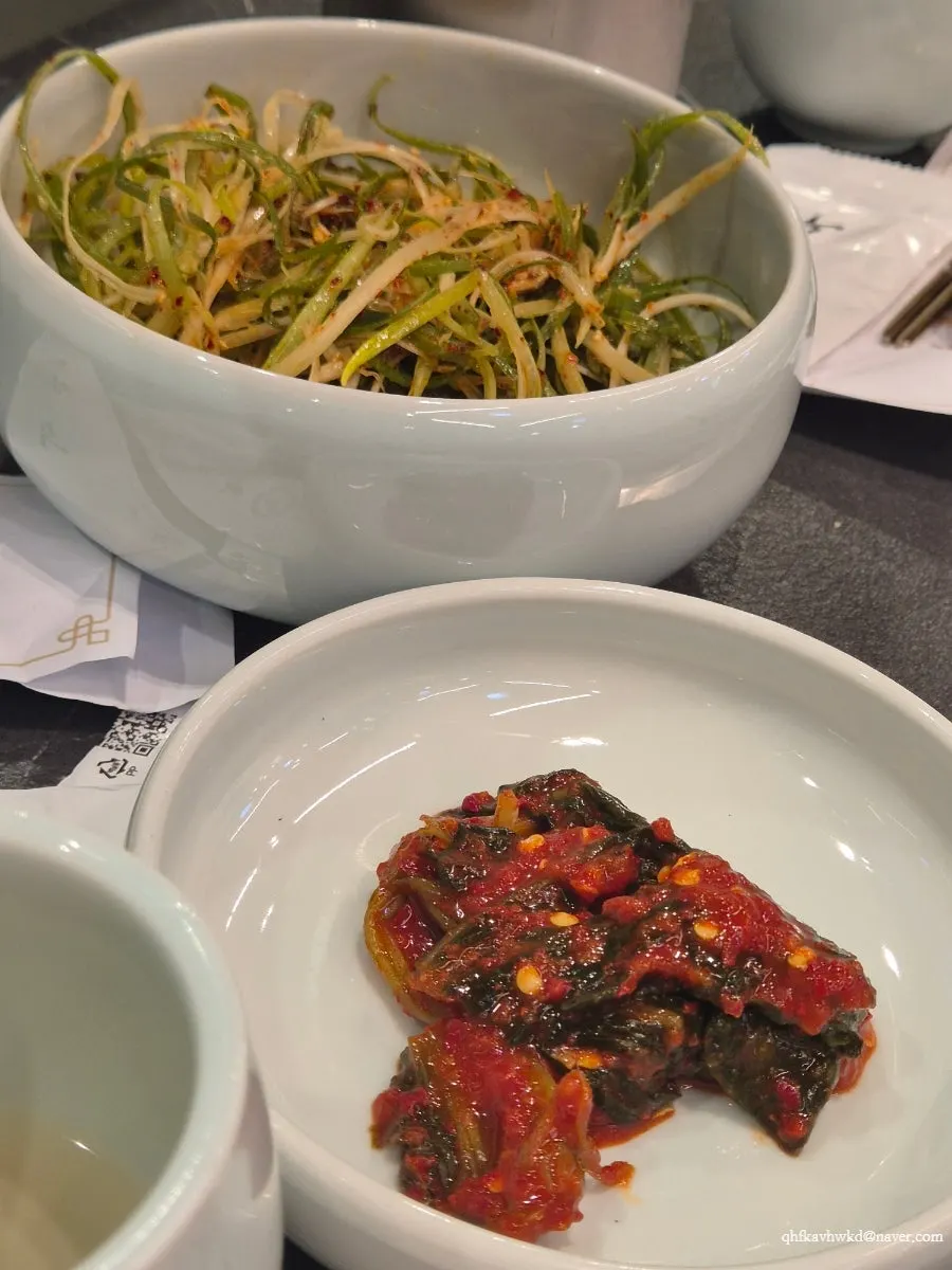Side dishes including scallion salad and gat-kimchi