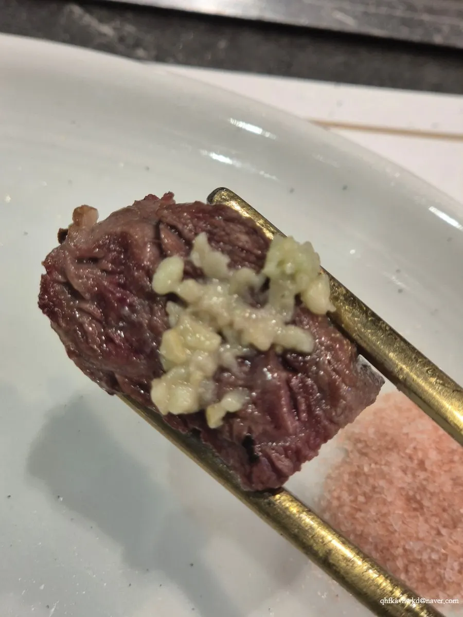 A piece of beef galbisal dipped in pink salt