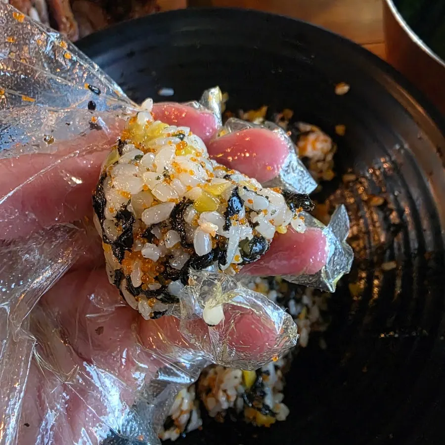 Eating the flying fish roe rice ball with a spoon