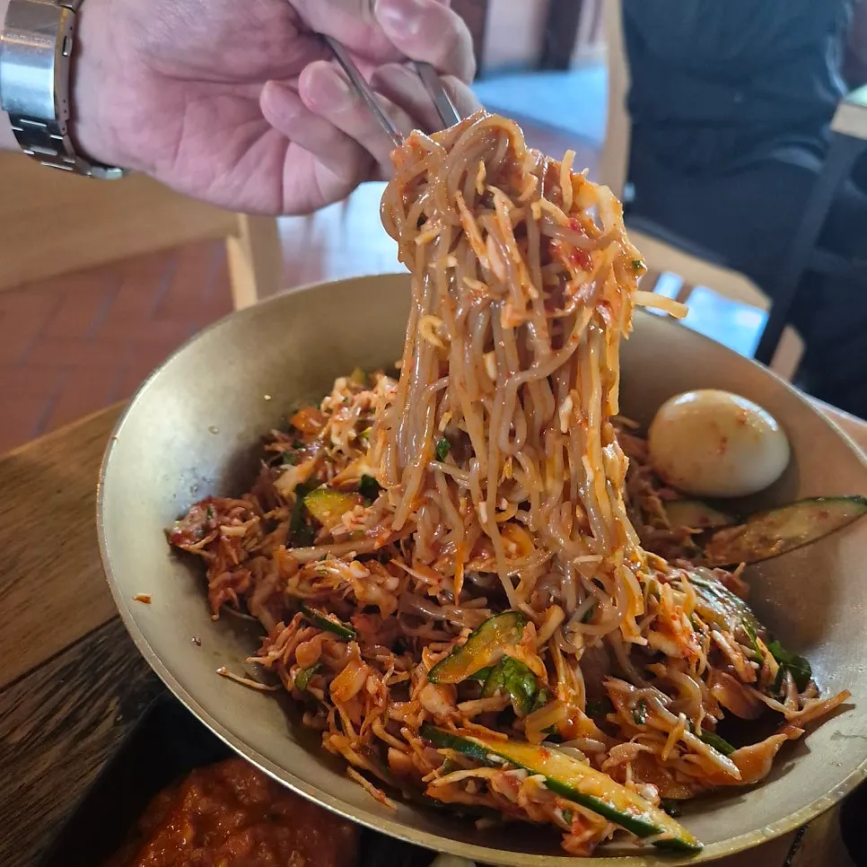Tangy and spicy makguksu with a piece of jokbal