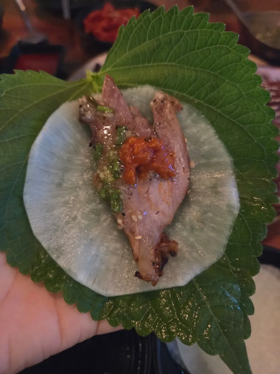 Jokbal dipped in fresh garlic sauce