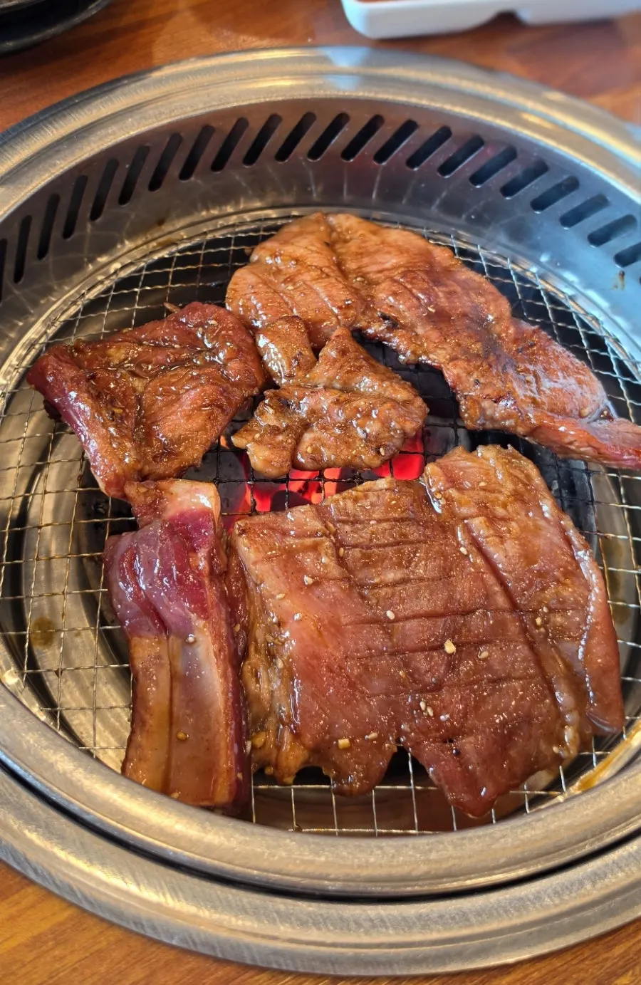 Seasoned pork galbi grilling over charcoal