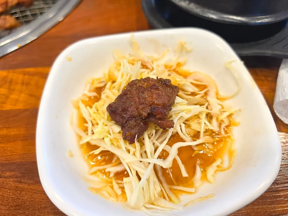 Lettuce wrap topped with shredded cabbage and ssamjang
