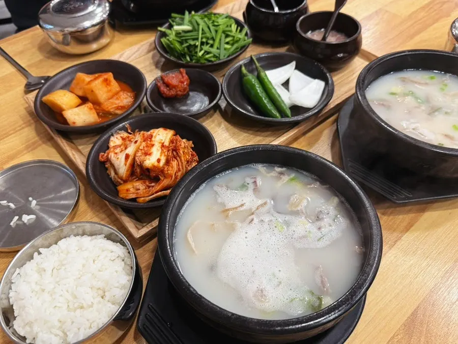 뽀얀 국물의 국밥과 반찬이 놓인 테이블