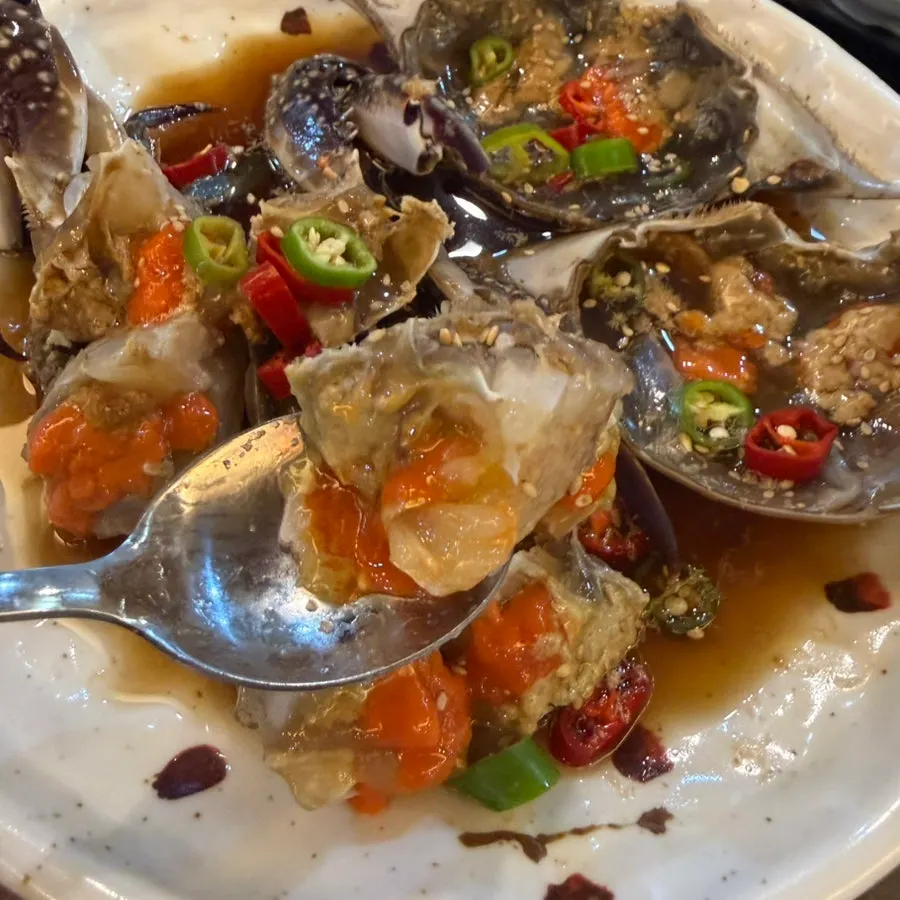 A bite of pot rice topped with soy-marinated crab