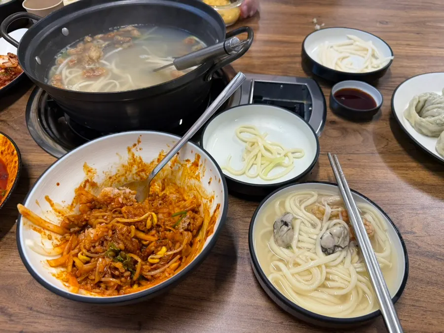 A bite of kalguksu with kimchi