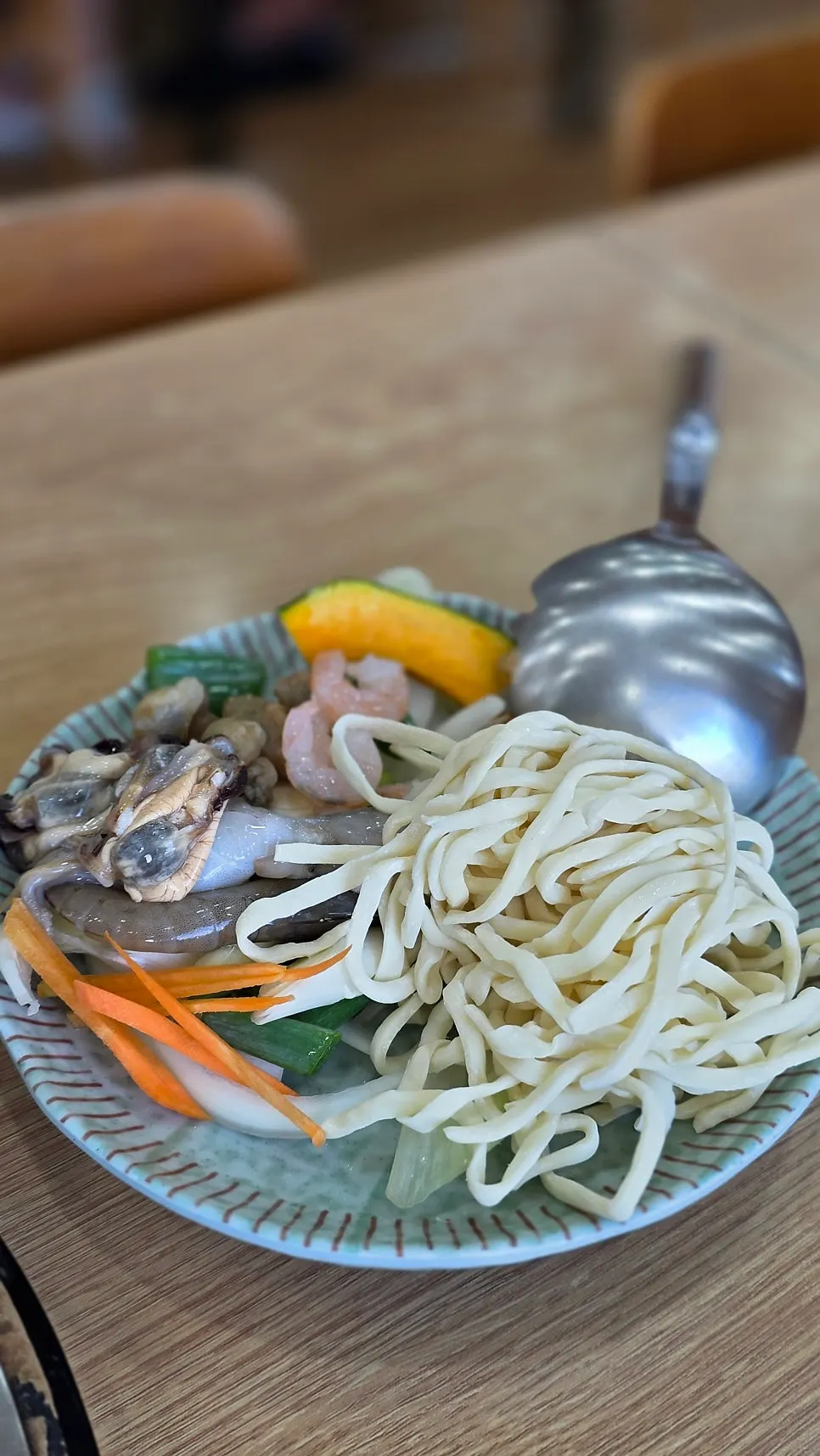 Pot of seafood kalguksu boiling at the table