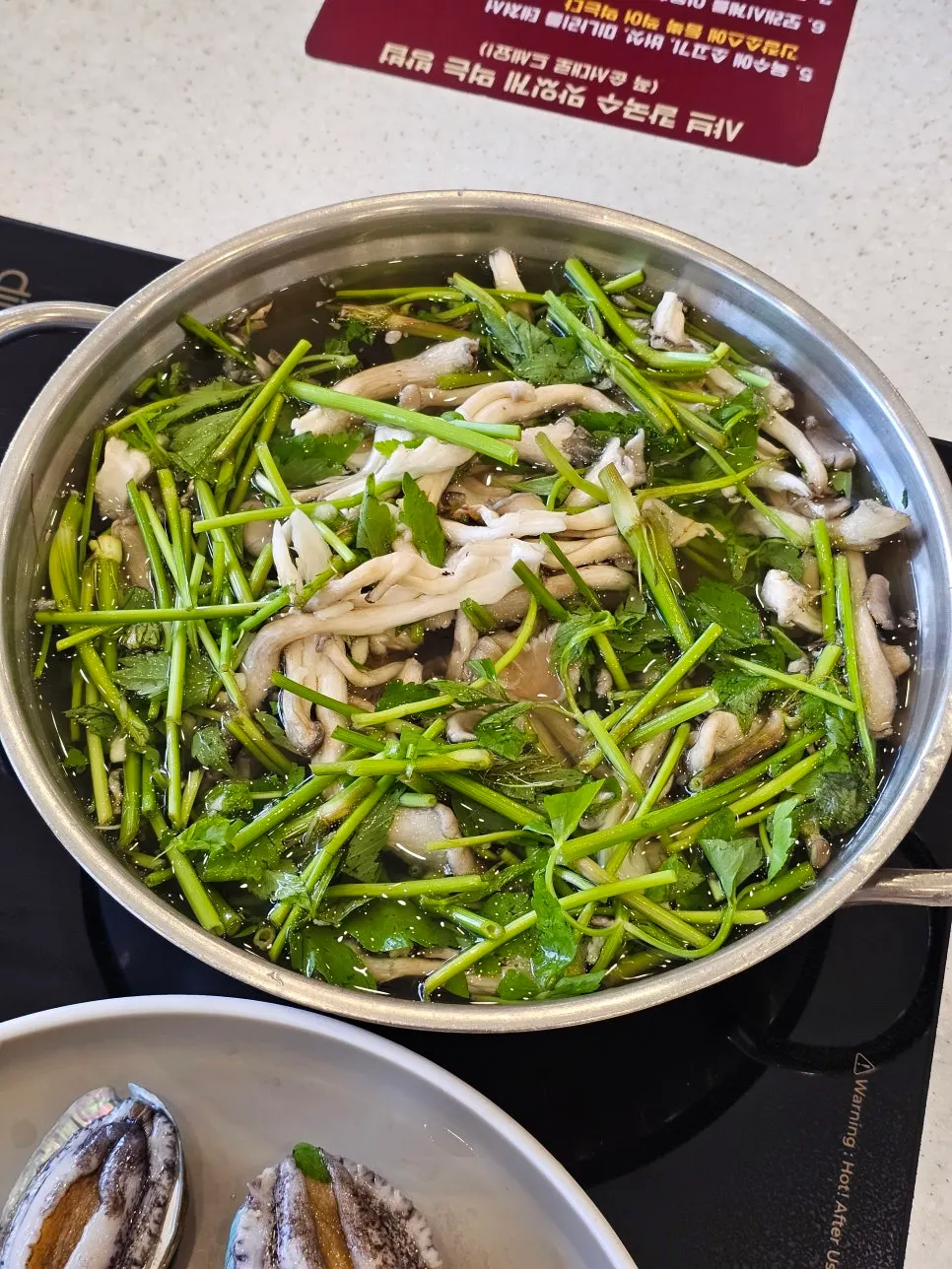 White broth with mushrooms and minari