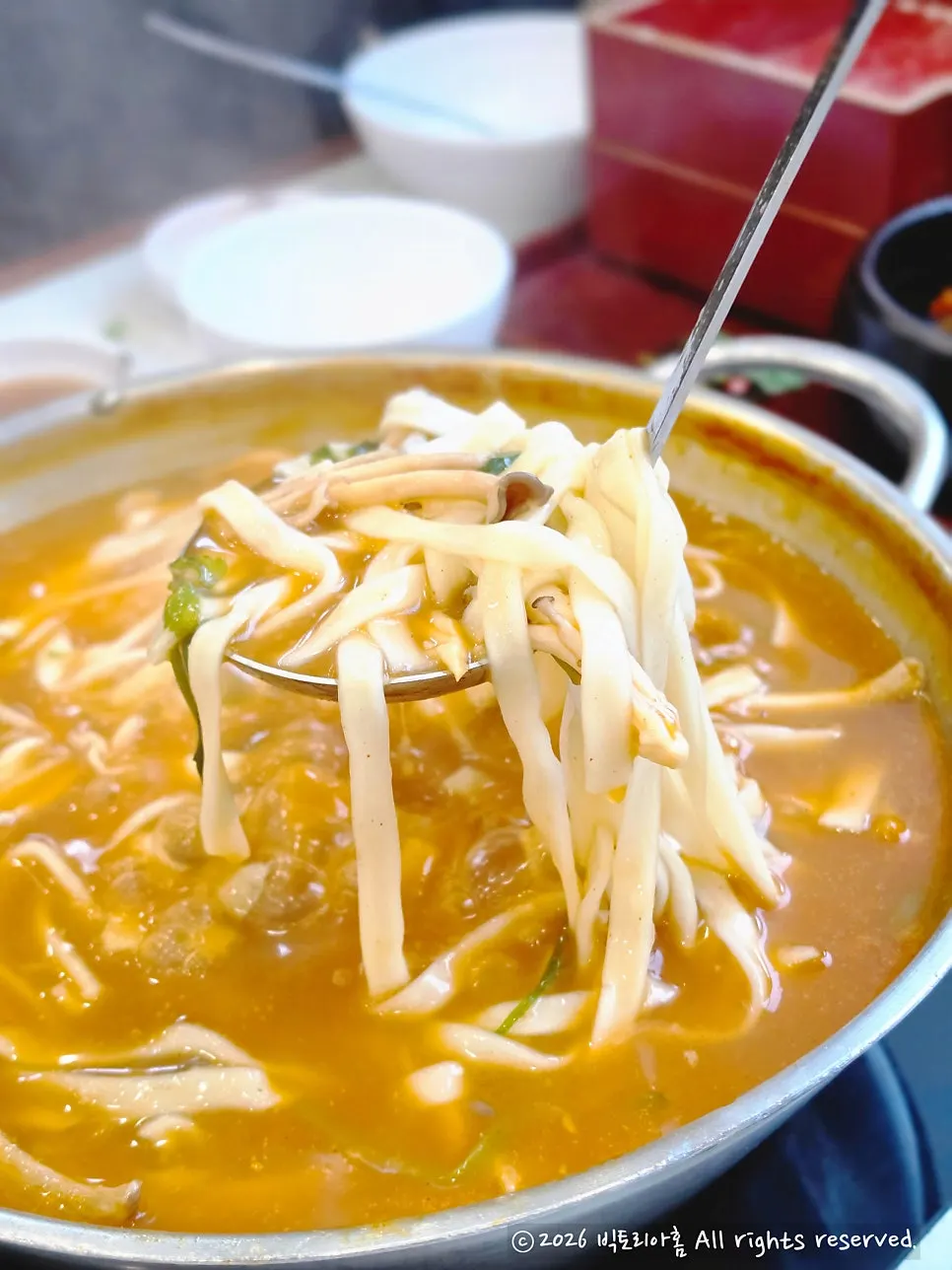 Vegetables being added to the spicy shabu broth pot