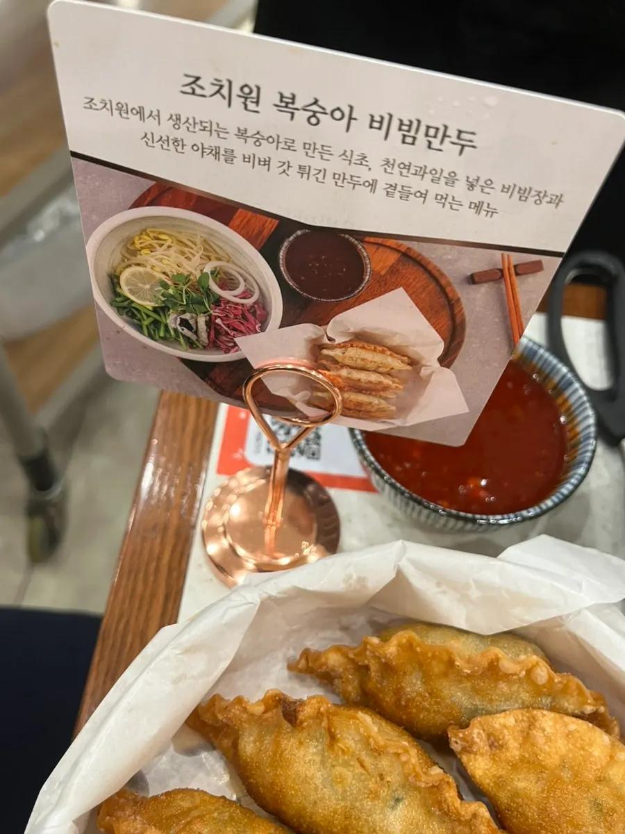 Peach bibim mandu sauce topped with fried mandu