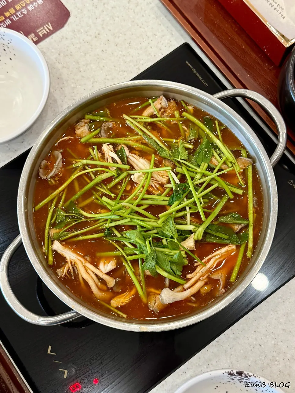 Pot of spicy beef brisket and minari shabu kalguksu broth
