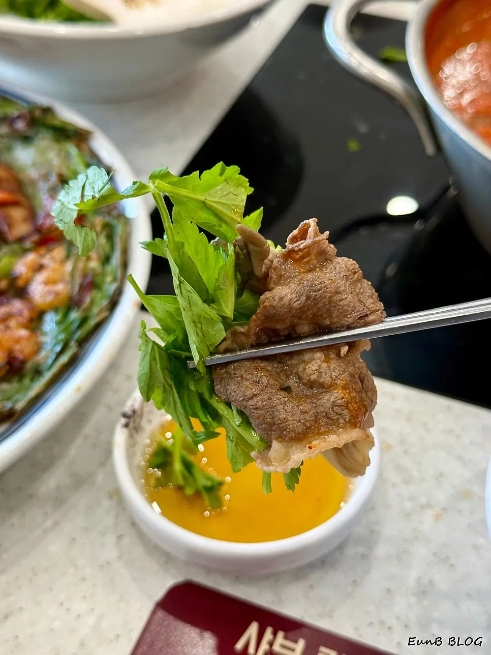 Brisket being dipped into boiling spicy broth